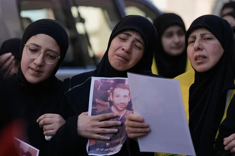 Para wanita berduka selama prosesi pemakaman tiga pejuang Hizbullah yang tewas dalam serangan Israel di desa Nabi Sheet di Lebanon timur, Sabtu, (21/02/2026).