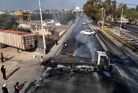 Seorang pria memadamkan api pada sebuah truk yang dibakar oleh kelompok kejahatan terorganisir sebagai bentuk perlawanan terhadap operasi penangkapan pemimpin Kartel Generasi Baru Jalisco, Nemesio Oseguera di Zapopan, Jalisco, Meksiko, Minggu (22/02/2026).