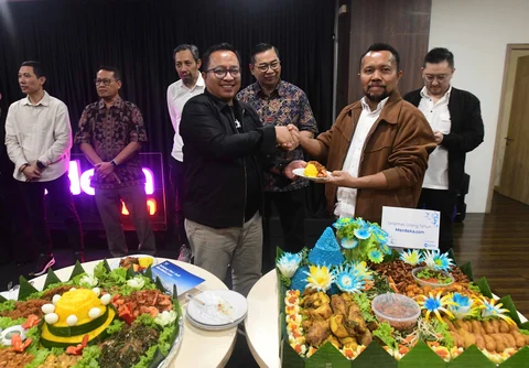 Pemred Merdeka.com Darojatun (kanan) menyerahkan nasi tumpeng kepada Direktur Konten Wenseslaus Manggut saat ulang tahun ke 14 Merdeka.com di Gedung KLY, Jakarta, Senin (23/02/2026).