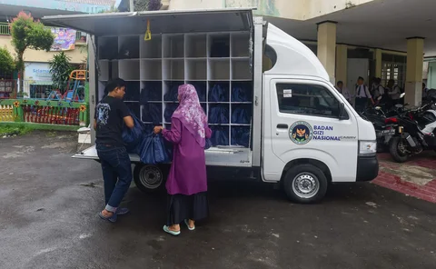 Petugas Satuan Pelayanan Pemenuhan Gizi (SPPG)  saat mendistribusikan makanan  program Makan Bergizi Gratis (MBG) Ramadan di SDI Al Hidayah, Cinere, Depok, Selasa (24/02/2026).