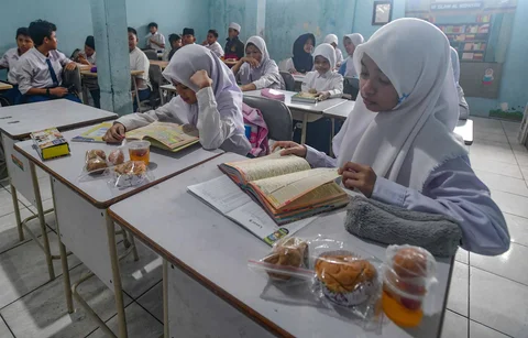 Murid kelas V menerima makanan  program Makan Bergizi Gratis (MBG) Ramadan di SDI Al Hidayah, Cinere, Depok, Selasa (24/02/2026).