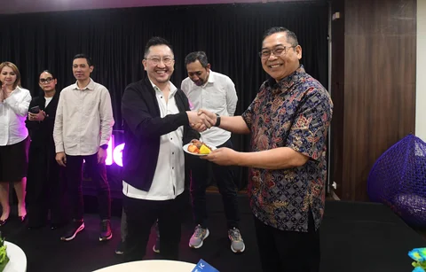 CEO Kapanlagi Universi (KLY) Danny Purnomo (kanan) menyerahkan nasi tumpeng kepada Corporate Secretary SCMA, Gilang Iskandar saat ulang tahun ke 14 Merdeka.com di Gedung KLY, Jakarta, Senin (23/02/2026)