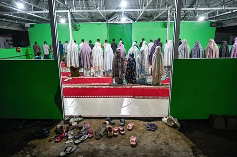 Warga yang tinggal di tempat penampungan sementara bagi korban banjir melaksanakan salat tarawih berjamaah di sebuah aula di Meureudu, distrik Pidie Jaya, provinsi Aceh Sabtu (21/02/2026).