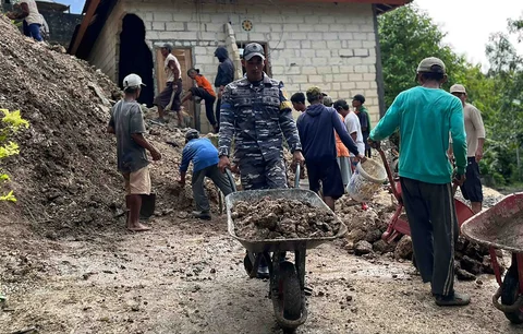 Personel Pos TNI AL Nusa Penida dan Koramil 1610-04/Nusa Penida bersama warga melakukan pembersihan material longsor yang menimpa rumah di Banjar Buah, Dusun Lemo, Nusa Penida, Bali, Kamis (26/02/2026).