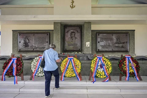 Seorang pria meletakkan bunga di monumen Karel Doorman selama upacara peringatan 84 tahun Pertempuran Laut Jawa di pemakaman perang Belanda Ereveld di Surabaya, Jawa Timur, Jumat (27/2/2026).