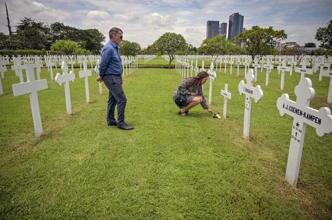 Warga meletakkan bunga Mawar di makam saat prosesi peringatan Pertempuran Laut Jawa di Ereveld (Makam Kehormatan) Kembang Kuning, Surabaya, Jawa Timur, Jumat (27/2/2026).