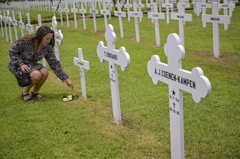 Warga meletakkan bunga Mawar di makam saat prosesi peringatan Pertempuran Laut Jawa di Ereveld (Makam Kehormatan) Kembang Kuning, Surabaya, Jawa Timur, Jumat (27/2/2026).