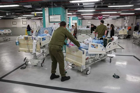 Personel keamanan Israel memindahkan seorang pasien ke tempat parkir di Pusat Medis Sourasky setelah sirene berbunyi di Tel Aviv, Israel, Sabtu (28/02/2026).