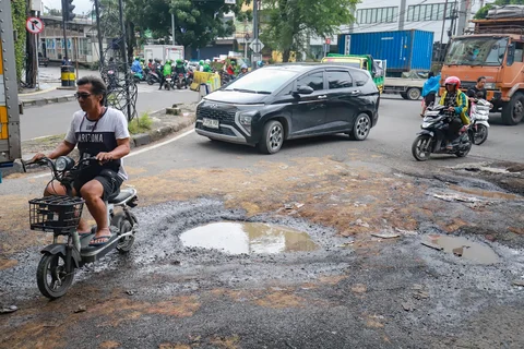 Sejumlah pengendara melewati jalan rusak  di Jalan  Mitra Bahari, Penjaringan Jakarta Utara, Selasa (03/02/2026).
