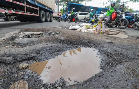 Sejumlah pengendara melewati jalan rusak  di Jalan Mitra Bahari, Penjaringan Jakarta Utara, Selasa (03/02/2026).