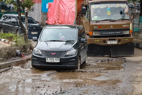 Sejumlah pengendara melewati jalan rusak  di Jalan Mitra Bahari, Penjaringan Jakarta Utara, Selasa (03/02/2026).