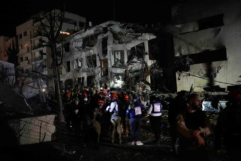 Para petugas dari Komando Pertahanan Dalam Negeri Israel menggeledah reruntuhan gedung apartemen yang rusak akibat serangan rudal Iran di Tel Aviv, Israel, Sabtu  (28/02/2026) malam.