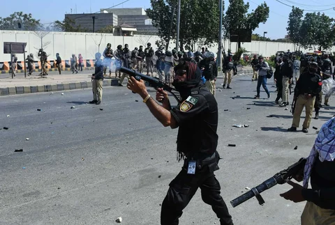 Seorang petugas polisi menembakkan gas air mata untuk membubarkan Muslim Syiah saat demo mengutuk pembunuhan Pemimpin Tertinggi Iran Ayatollah Ali Khamenei, di dekat Konsulat AS di Karachi, Pakistan, Minggu, (01/03/2026).