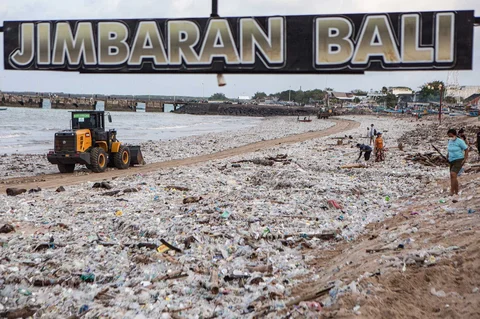 Para pekerja dan warga membersihkan puing-puing laut dan sampah plastik yang terdampar di Pantai Jimbaran, Bali,  Selasa (10/03/2026).