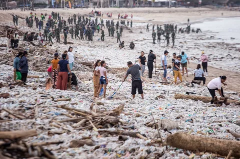 Para pekerja dan warga membersihkan puing-puing laut dan sampah plastik yang terdampar di Pantai Jimbaran, Bali,  Selasa (10/03/2026).