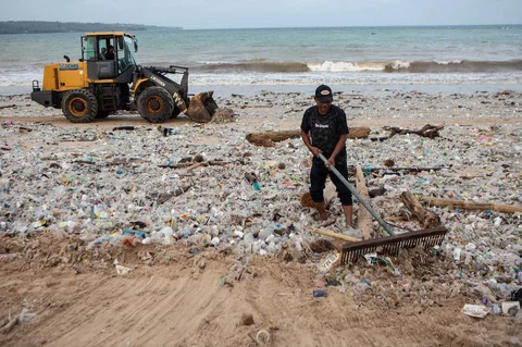 Para pekerja dan warga membersihkan puing-puing laut dan sampah plastik yang terdampar di Pantai Jimbaran, Bali,  Selasa (10/03/2026).