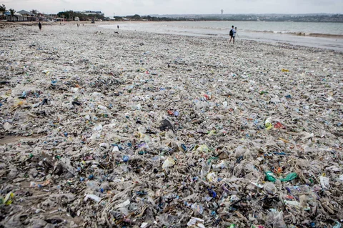Para pekerja dan warga membersihkan puing-puing laut dan sampah plastik yang terdampar di Pantai Jimbaran, Bali,  Selasa (10/03/2026).