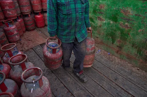 Seorang pekerja membagikan tabung gas petroleum cair (LPG) rumah tangga kepada pelanggan di Srinagar, Kashmir yang dikuasai India, Sabtu, Sabtu, (14/03/2026).