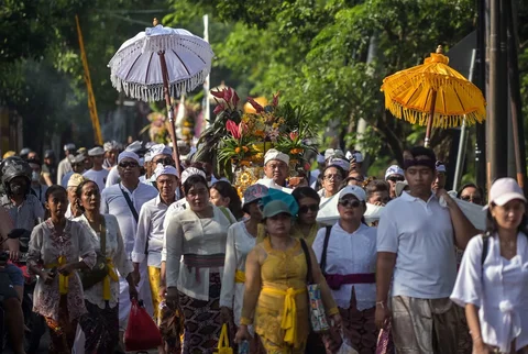 Umat Hindu berjalan dengan membawa benda sakral menuju lokasi upacara Melasti di Pantai Kenjeran, Surabaya, Jawa Timur, Sabtu (14/3/2026).