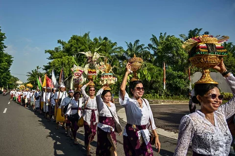 Umat Hindu berjalan dengan membawa benda sakral menuju lokasi upacara Melasti di Pantai Kenjeran, Surabaya, Jawa Timur, Sabtu (14/3/2026).