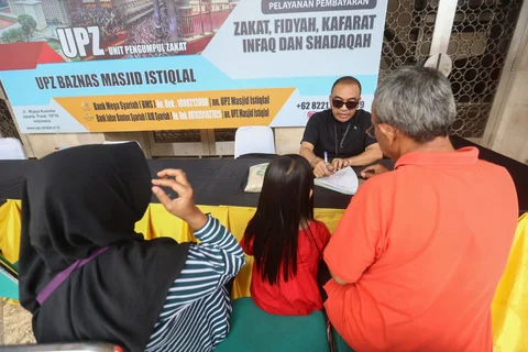 Seorang amil zakat melayani muzakki yang akan membayar zakat fitrah di Masjid Istiqlal, Jakarta, Minggu (15/03/2026).