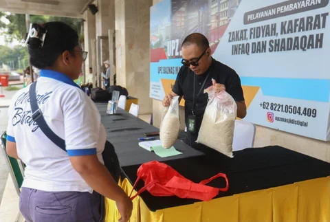 Seorang amil zakat melayani muzakki yang akan membayar zakat fitrah di Masjid Istiqlal, Jakarta, Minggu (15/03/2026).