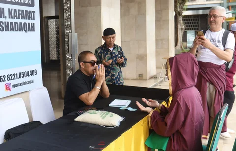 Seorang amil zakat melayani muzakki yang akan membayar zakat fitrah di Masjid Istiqlal, Jakarta, Minggu (15/03/2026).