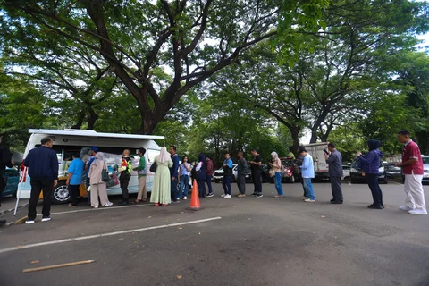 Sejumlah warga antre menukarkan uang di pelayanan mobil kas keliling Bank Indonesia di Stasiun Gambir, Jakarta, Senin (16/03/2026).