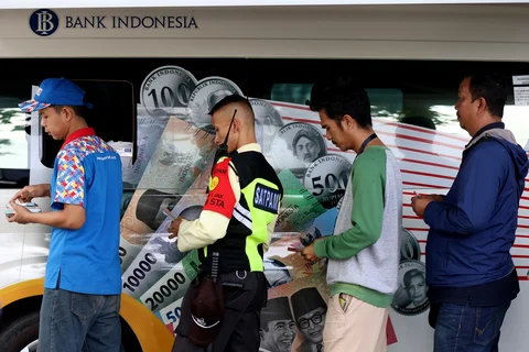 Sejumlah warga antre menukarkan uang di pelayanan mobil kas keliling Bank Indonesia di Stasiun Gambir, Jakarta, Senin (16/03/2026).