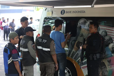 Sejumlah warga antre menukarkan uang di pelayanan mobil kas keliling Bank Indonesia di Stasiun Gambir, Jakarta, Senin (16/03/2026).