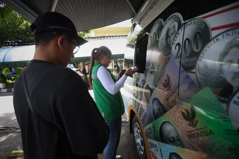 Sejumlah warga antre menukarkan uang di pelayanan mobil kas keliling Bank Indonesia di Stasiun Gambir, Jakarta, Senin (16/03/2026).