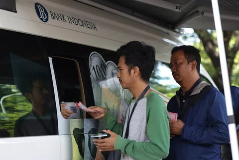 Sejumlah warga antre menukarkan uang di pelayanan mobil kas keliling Bank Indonesia di Stasiun Gambir, Jakarta, Senin (16/03/2026).