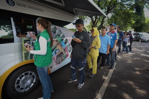 Sejumlah warga antre menukarkan uang di pelayanan mobil kas keliling Bank Indonesia di Stasiun Gambir, Jakarta, Senin (16/03/2026).