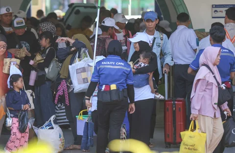 Pemudik tujuan Surabaya berjalan menuju gerbong kereta Jayakarta di Stasiun Senen, Jakarta, Senin (16/01/2026).