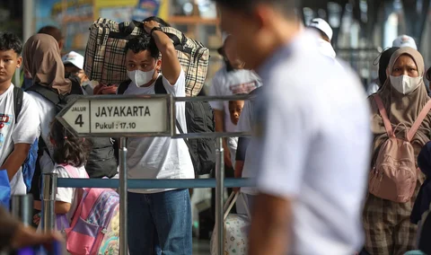 Pemudik tujuan Surabaya berjalan menuju gerbong kereta Jayakarta di Stasiun Senen, Jakarta, Senin (16/01/2026).