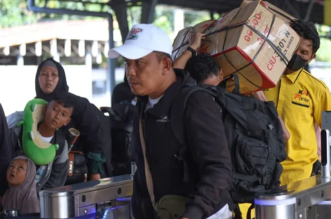 Pemudik tujuan Surabaya berjalan menuju gerbong kereta Jayakarta di Stasiun Senen, Jakarta, Senin (16/01/2026).