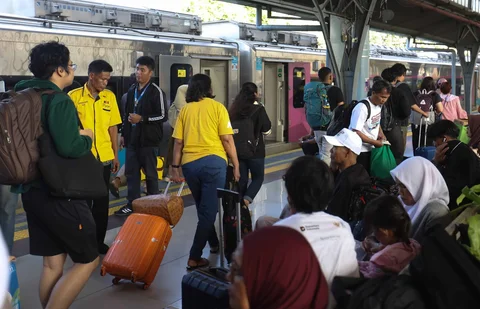 Pemudik tujuan Surabaya berjalan menuju gerbong kereta Jayakarta di Stasiun Senen, Jakarta, Senin (16/01/2026).