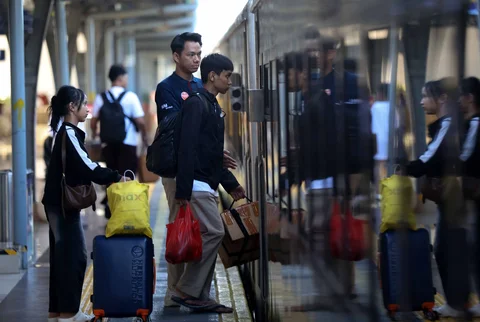 Pemudik tujuan Surabaya berjalan menuju gerbong kereta Jayakarta di Stasiun Senen, Jakarta, Senin (16/01/2026).