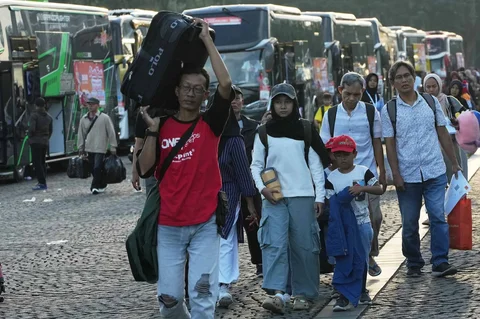 Sejumlah pemudik  berjalan menuju bus  dalam program mudik gratis bersama Pemerintah Provinsi DKI Jakarta di kawasan Silang Monas, Jakarta, Kamis (17/03/2025).