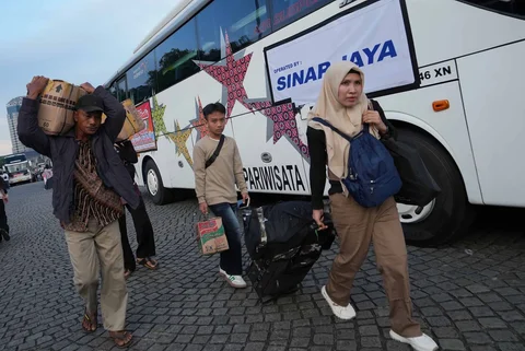 Sejumlah pemudik  berjalan menuju bus  dalam program mudik gratis bersama Pemerintah Provinsi DKI Jakarta di kawasan Silang Monas, Jakarta, Kamis (17/03/2025).