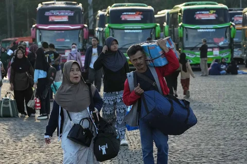 Sejumlah pemudik  berjalan menuju bus  dalam program mudik gratis bersama Pemerintah Provinsi DKI Jakarta di kawasan Silang Monas, Jakarta, Kamis (17/03/2025).