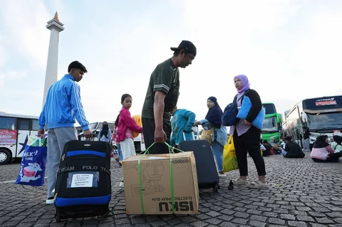 Sejumlah pemudik  berjalan menuju bus  dalam program mudik gratis bersama Pemerintah Provinsi DKI Jakarta di kawasan Silang Monas, Jakarta, Kamis (17/03/2025).