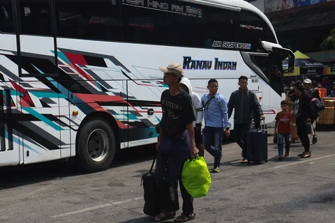 Pemudik berjalan menuju bus di Terminal Kampung Rambutan, Jakarta, Rabu (18/03/2026), menjelang puncak arus mudik Lebaran dengan tujuan berbagai kota di Jawa Barat dan Jawa Tengah.
