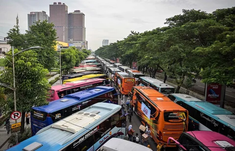 Warga berdatangan untuk menaiki bus gratis yang disediakan Pemprov Jawa Timur di Surabaya, Kamis (19/03/2026).