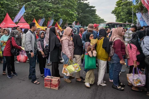 Warga mengantre untuk menerima paket hadiah dan mendaftar ulang untuk bus gratis yang disediakan pemprov Jawa timur di Surabya, Kamis (19/03/2026).