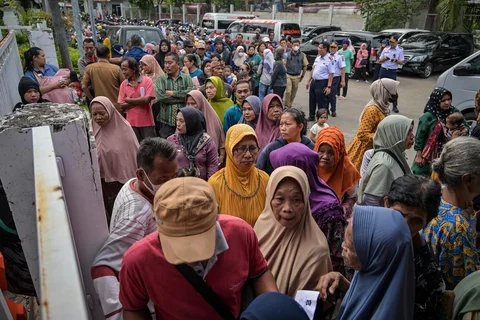 Warga mengantre untuk menerima pakaian, bahan makanan pokok, dan perlengkapan rumah tangga yang dibagikan oleh Asosiasi Organisasi Wanita (GOW) bersama Pemkot Surabaya dalam aksi sosial tahunan Ramadan di Surabaya, Senin (02/03/2026).