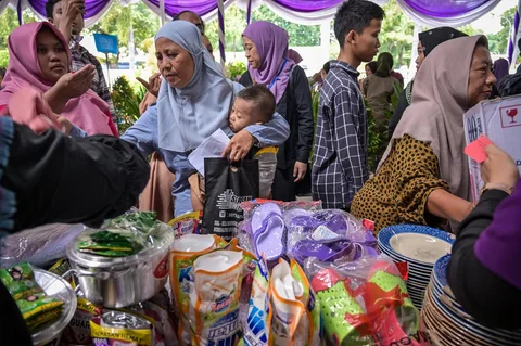 Warga menerima barang-barang gratis seperti pakaian, bahan makanan pokok, dan perlengkapan rumah tangga yang disediakan oleh Asosiasi Organisasi Wanita (GOW) dan Pemkot Surabaya daerah dalam aksi sosial tahunan Ramadan di Surabaya, Senin (02/03/2026).