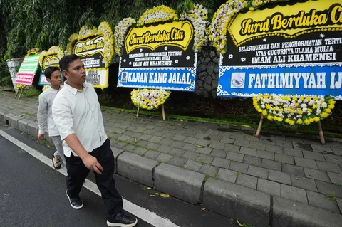 Warga berjalan melewati karangan bunga belasungkawa untuk Pemimpin Tertinggi Iran Ayatollah Ali Khamenei di luar kediaman duta besar Iran, di Jakarta, Senin (02/02/2026).