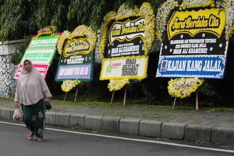 Warga  berjalan melewati karangan bunga belasungkawa untuk Pemimpin Tertinggi Iran Ayatollah Ali Khamenei di luar kediaman duta besar Iran, di Jakarta, Senin (02/02/2026).
