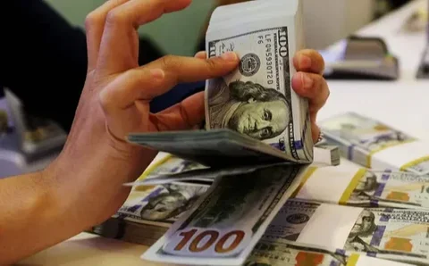 Karyawan menunjukkan uang dolar AS dan rupiah di Jakarta, Rabu (30/12/2020). Nilai tukar rupiah di pasar spot ditutup menguat 80 poin atau 0,57 persen ke level Rp 14.050 per dolar AS. (Liputa